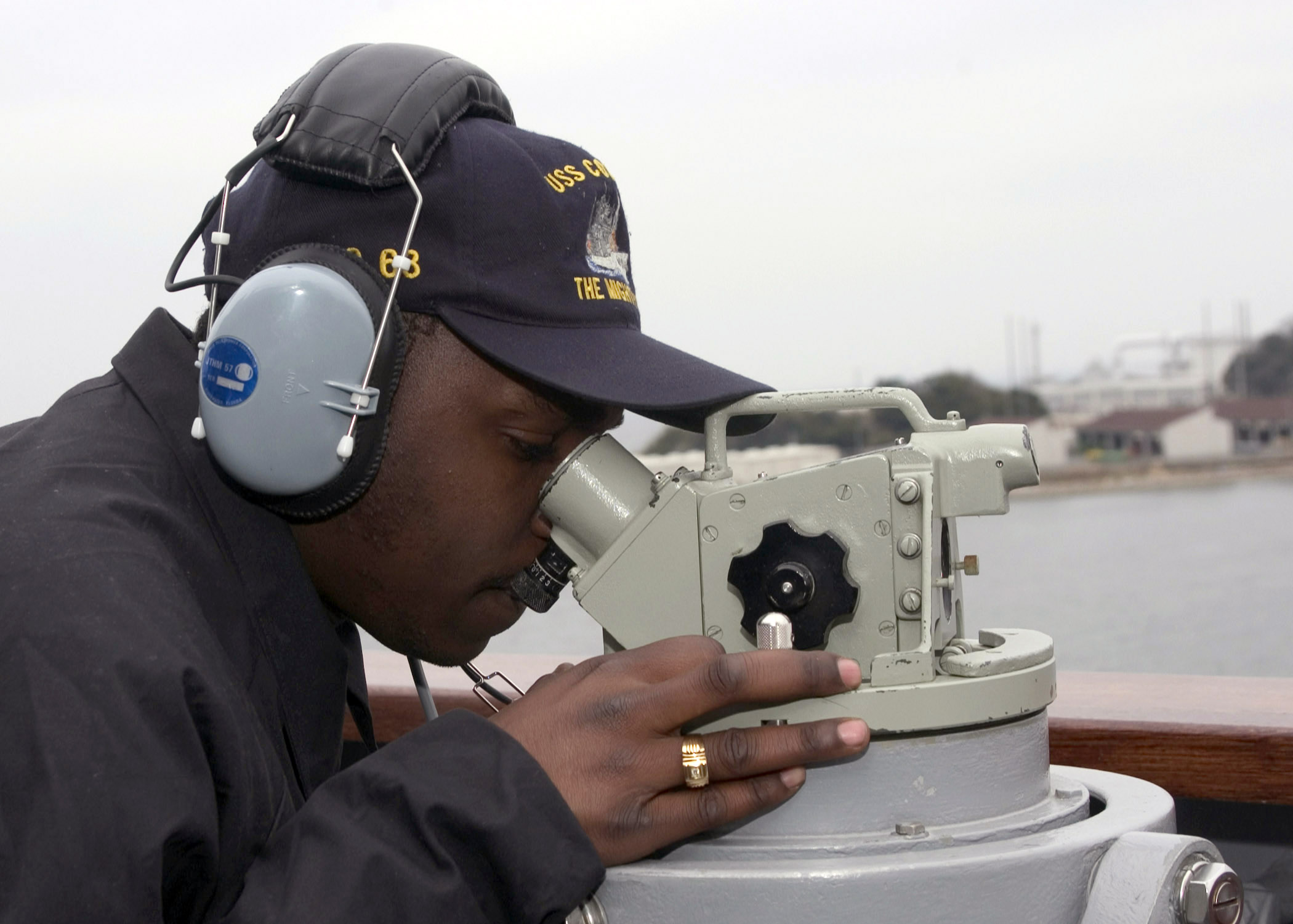 US Navy 060309-N-5686B-003 Quartermaster Seaman Joshua Houston looks through the gyro compass repeater during a training evolution aboard the guided-missile cruiser USS Cowpens (CG 63)
