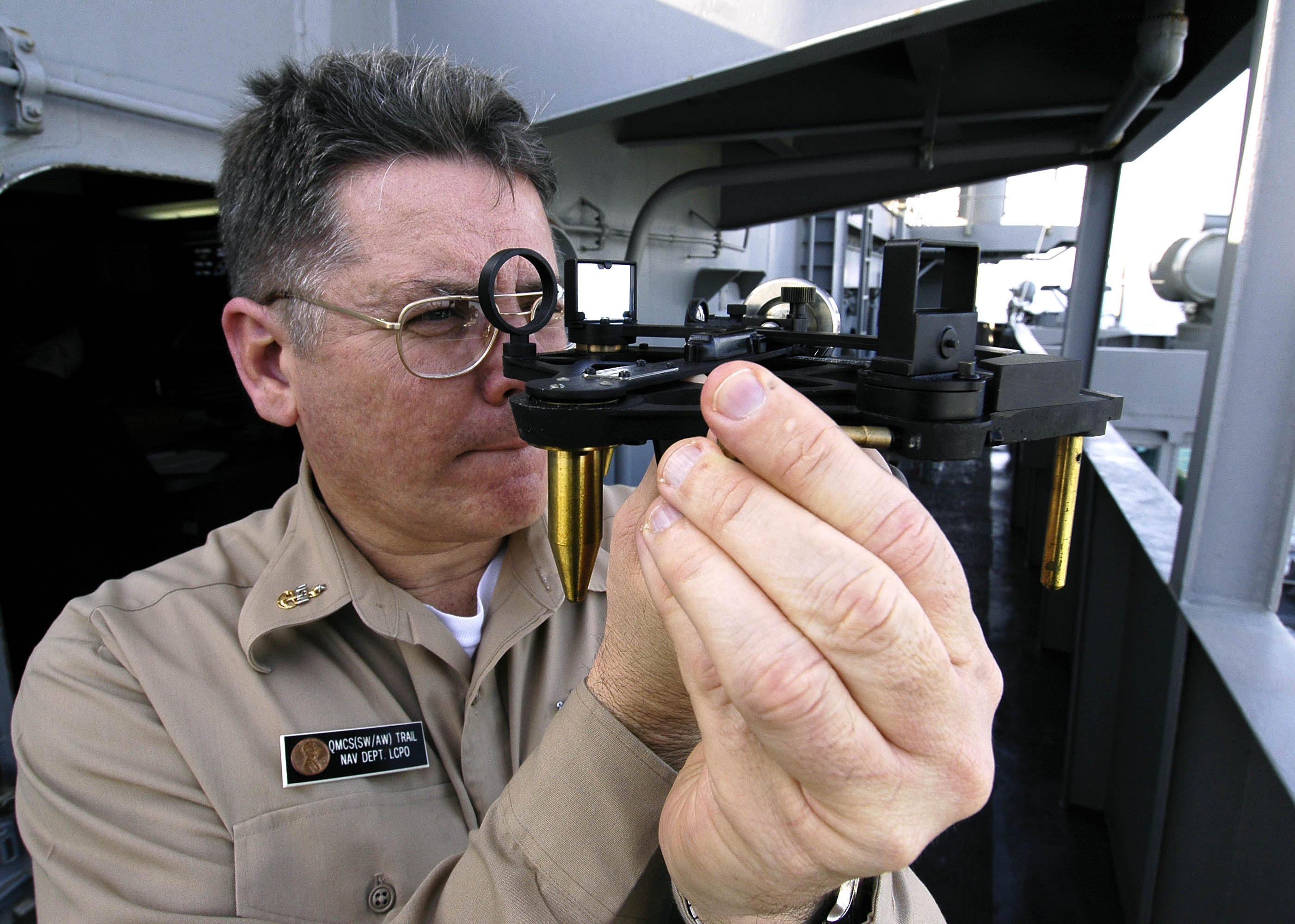 US Navy 060403-N-7981E-085 Senior Chief Quartermaster John Trail demonstrates the use of a stadimeter, a navigational instrument used to determine the distance from one object to another
