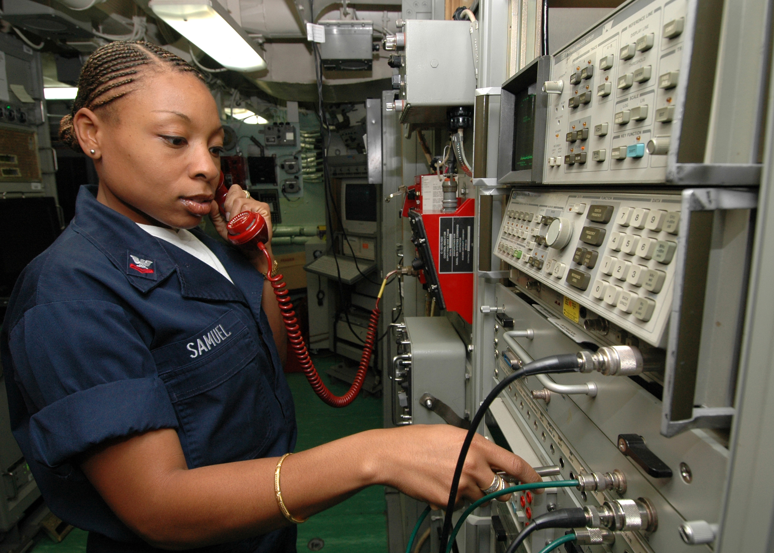 US Navy 061023-N-6403R-012 Information Systems Technician 2nd Class Hendra Samuel from Wayne, N.J., checks for a shipboard to shipboard circuit in the joint message center (JMC) shop aboard USS Iwo Jima (LHD 7)