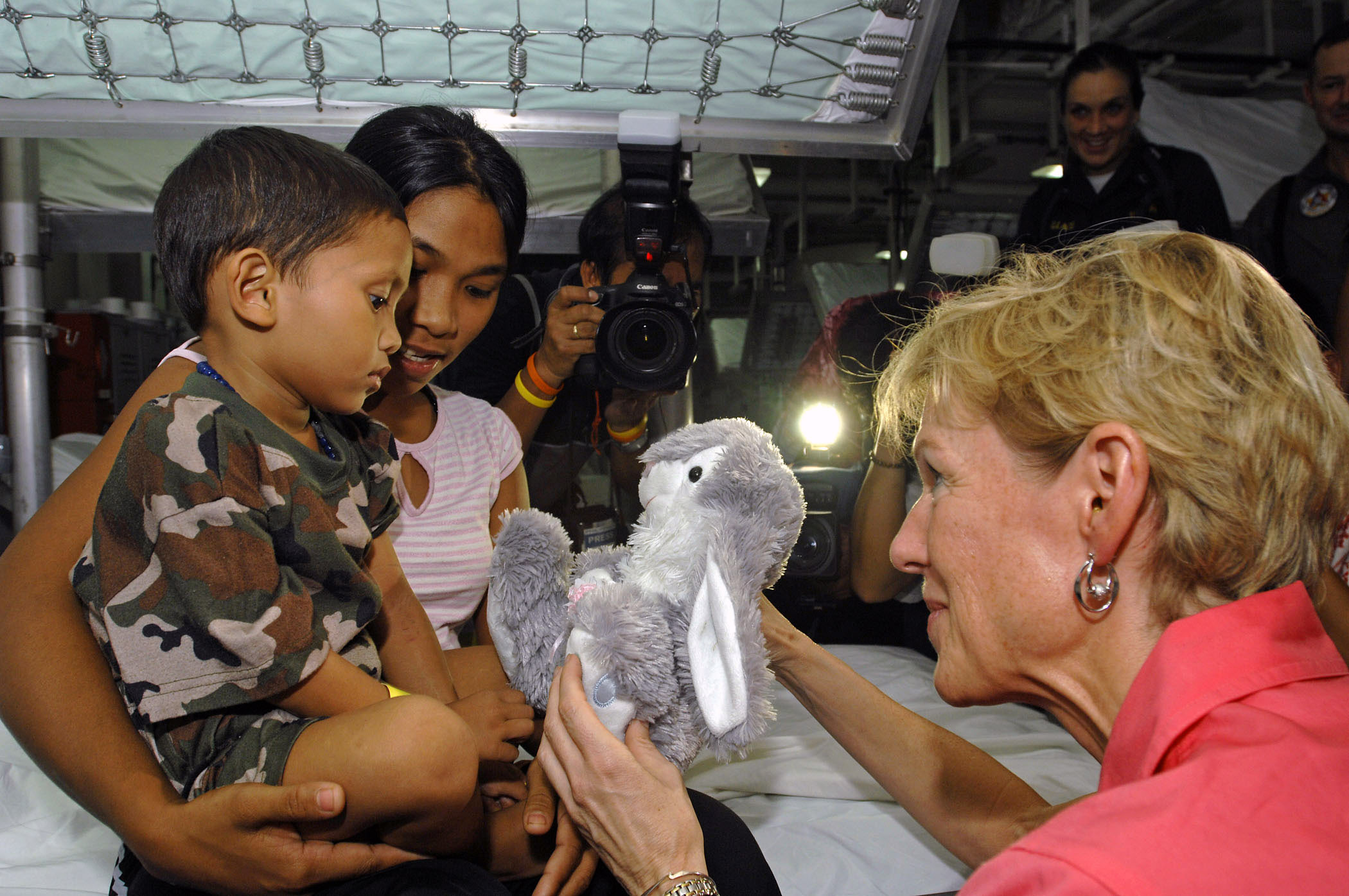 US Navy 070628-N-4954I-021 U.S. Ambassador to the Philippines, The Honorable Kristie A. Kenney, presents a stuffed bunny to a Filipino child as his mother holds him