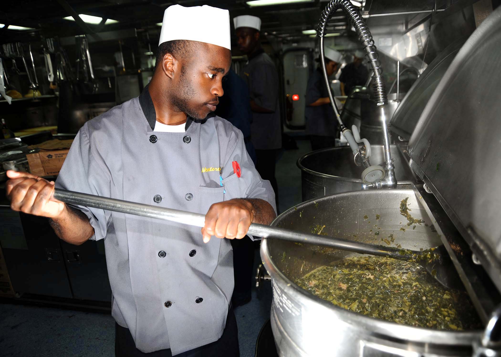 US Navy 081127-N-7571S-011 Culinary Specialist Seaman Freddie Green prepares collard greens for the crew's Thanksgiving dinner