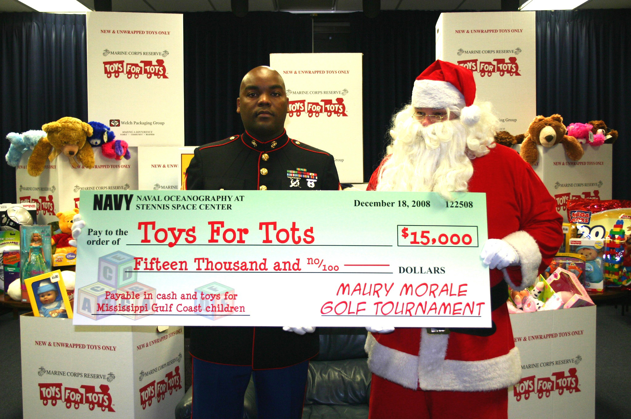 US Navy 081218-N-6981B-006 Gunnery Sgt. Theodis Jones accepts a $15,000 check for the U.S. Marine Corps annual Toys for Tots campaign