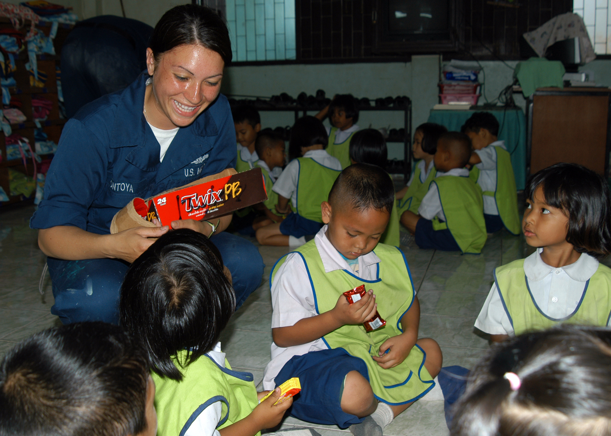 US Navy 090220-N-6692A-063 Aviation Ordnanceman Airman Francheska Montoya shares candy with a group of Thai kindergarteners
