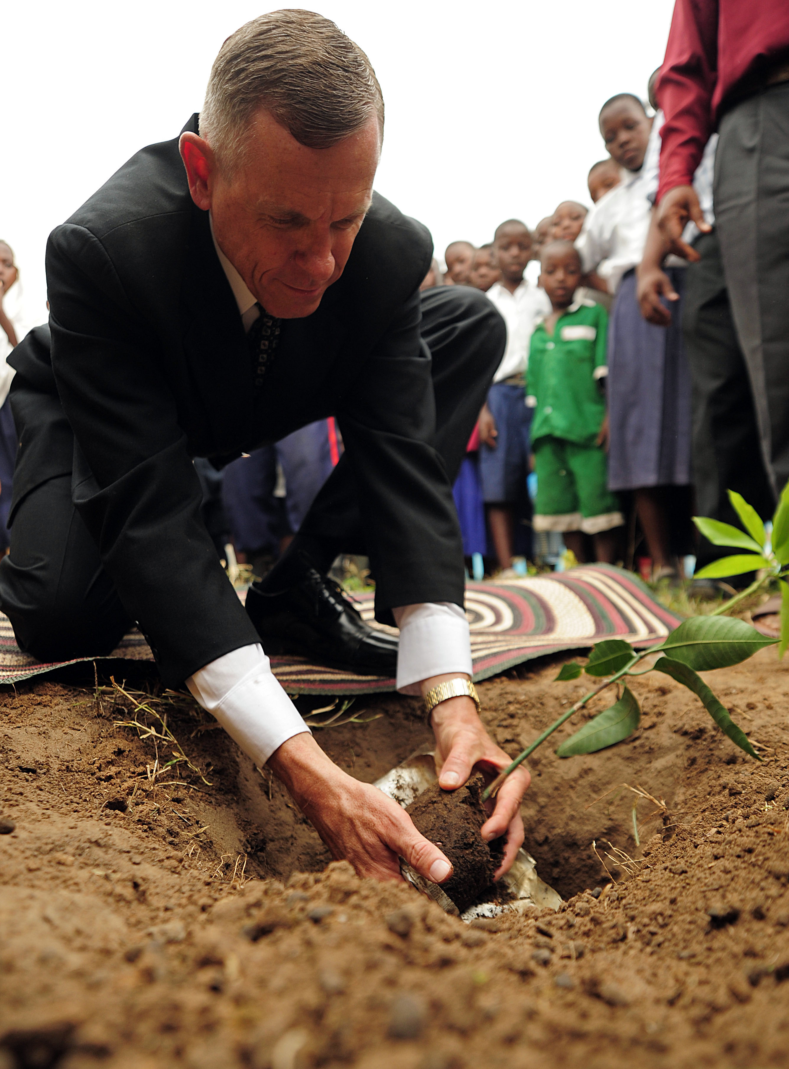 US Navy 090610-F-3682S-401 U.S. Navy Captain Mark Sparling, from Combined Joint Task Force-Horn of Africa plants a memorial mango tree during the Ziwani Primary School Renovation Dedication