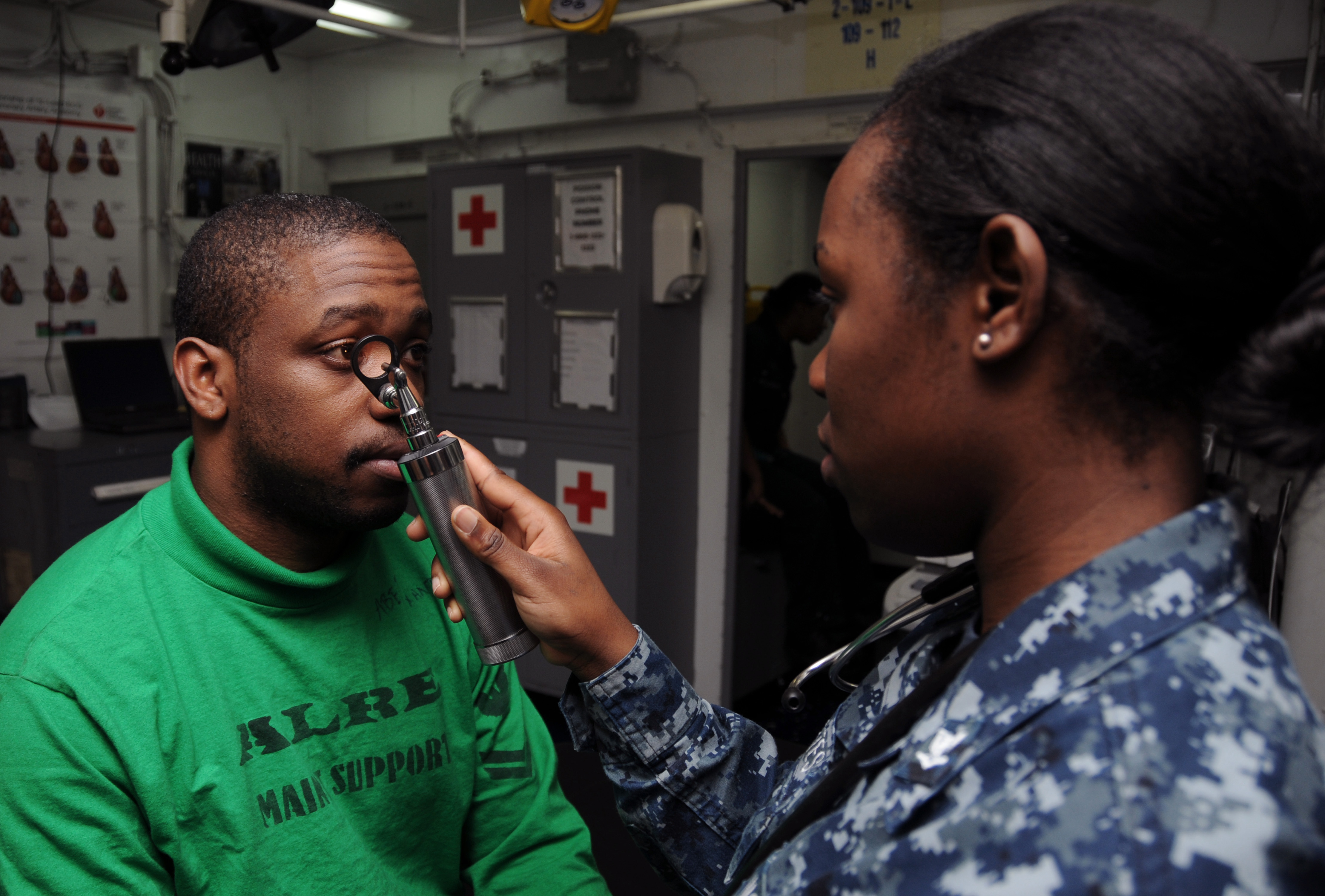 US Navy 120119-N-NB694-023 Hospital Corpsman 3rd Class Kerchelle Cortes conducts a medical examination on Aviation Boatswain's Mate (Equipment) 2nd