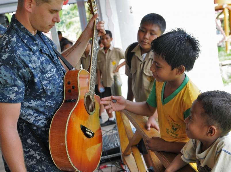 Flickr - Official U.S. Navy Imagery - A Sailor lets local Indonesian children strum his guitar during a Pacific Partnership 2012 community service project.