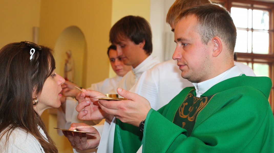 a young Catholic woman takes Jesus Christ in the Holy Communion