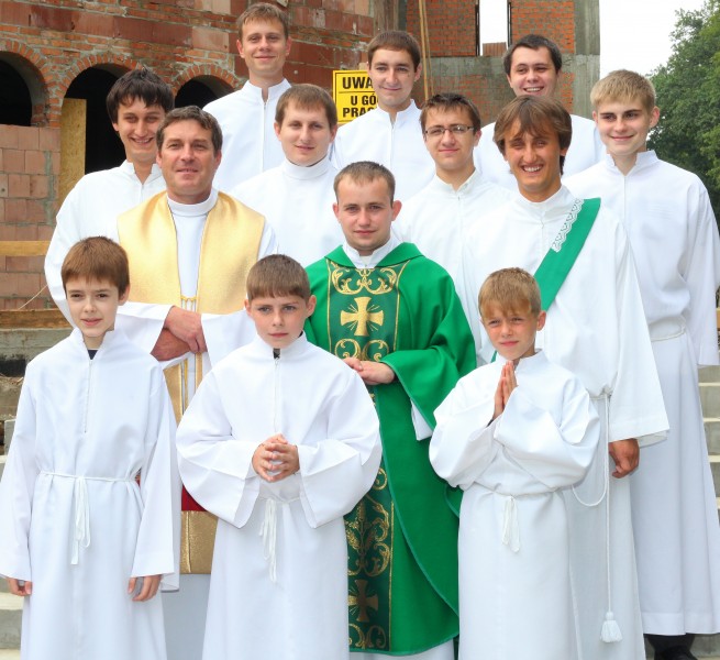 ministrants, priests and a deacon near a building of a new Church