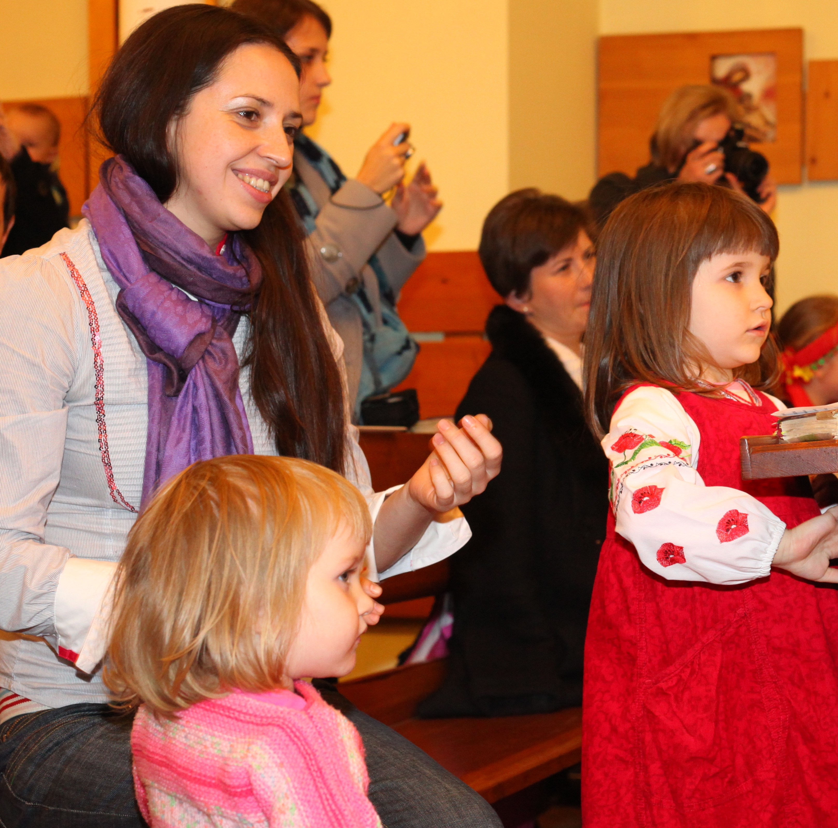 an amazingly attractive smiling charming beautiful young brunette Catholic woman in a Church and two cute child girls, photo 5