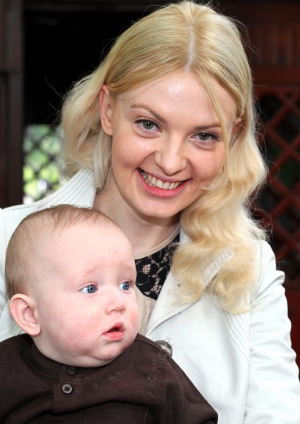 a pretty blond woman with her baby son photographed in June 2013
