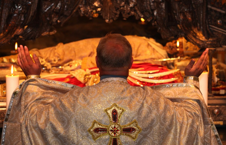 a priest praying near relics in Saint Ambrose basilica, Milan, August 2013, picture 9
