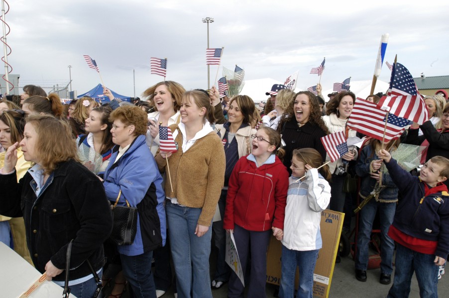 US Navy 050304-N-6477M-454 Friends and families of crew members assigned to the Nimitz-class aircraft carrier USS Abraham Lincoln (CVN-72) cheer as the ship approaches the pier at their homeport of Naval Station Everett, Wash