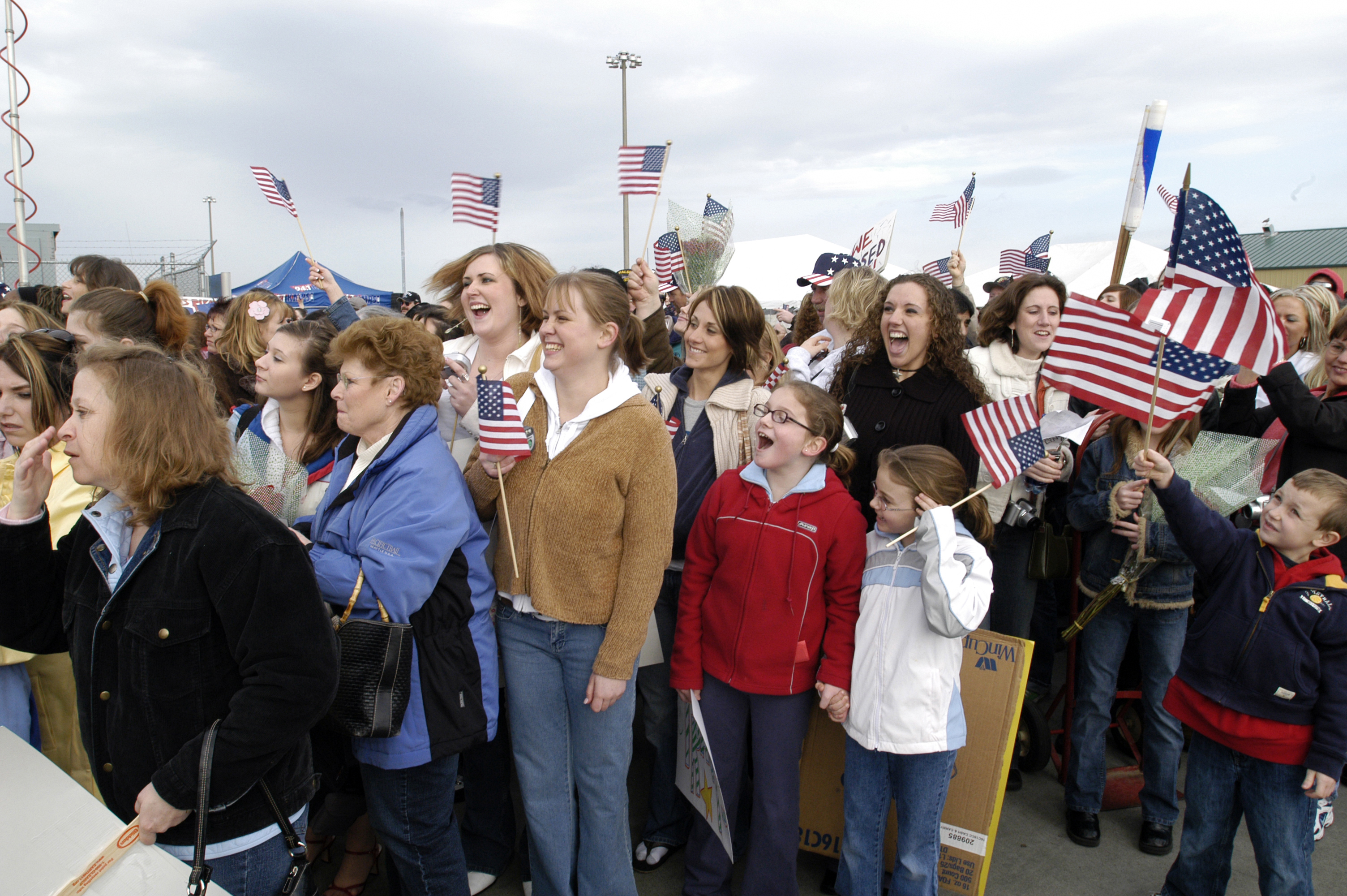 US Navy 050304-N-6477M-454 Friends and families of crew members assigned to the Nimitz-class aircraft carrier USS Abraham Lincoln (CVN-72) cheer as the ship approaches the pier at their homeport of Naval Station Everett, Wash