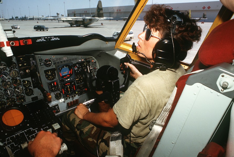 A ground crew member sits in the co-pilot's seat of a KC-135 Stratotanker aircraft as she helps conduct a maintenance check during Operation Desert Shield DF-ST-91-08793