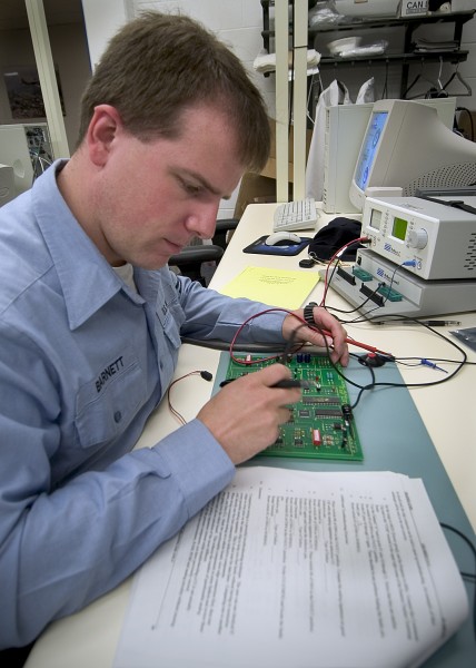 US Navy 040831-N-5134H-001 Electricians Mate 3rd Class Jason Burnett, of Snohomish, Wash., takes readings from a circuit board