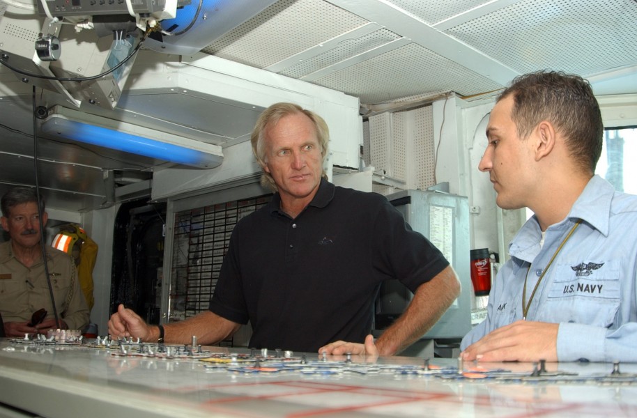 US Navy 041011-N-4565G-002 Aviation Boatswain Mate 3rd Class Greg Black explains the oujia board, in Hangar Deck Control, to professional golfer Greg Norman