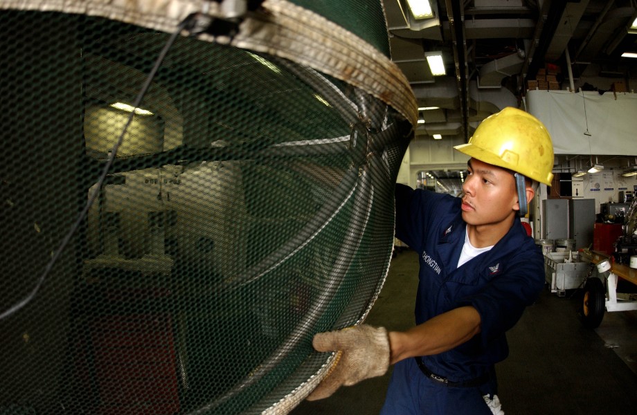US Navy 050714-N-0413R-021 Aviation Machinist^rsquo,s Mate 3rd Class Jalvin Yuchongtian inspects the cover for an J-52 jet engine