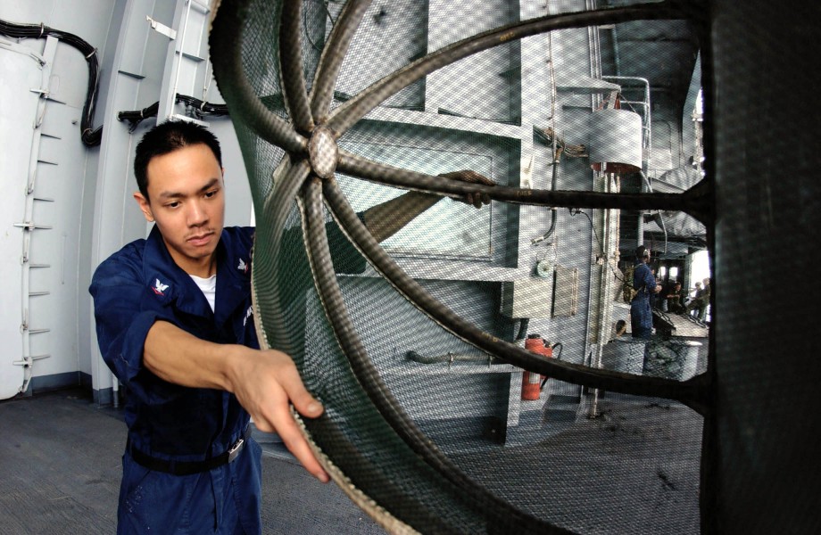 US Navy 050728-N-0413R-077 Aviation Machinist's Mate 3rd Class Jalvin Yuchongtian, inspects the cover for an J-52 engine