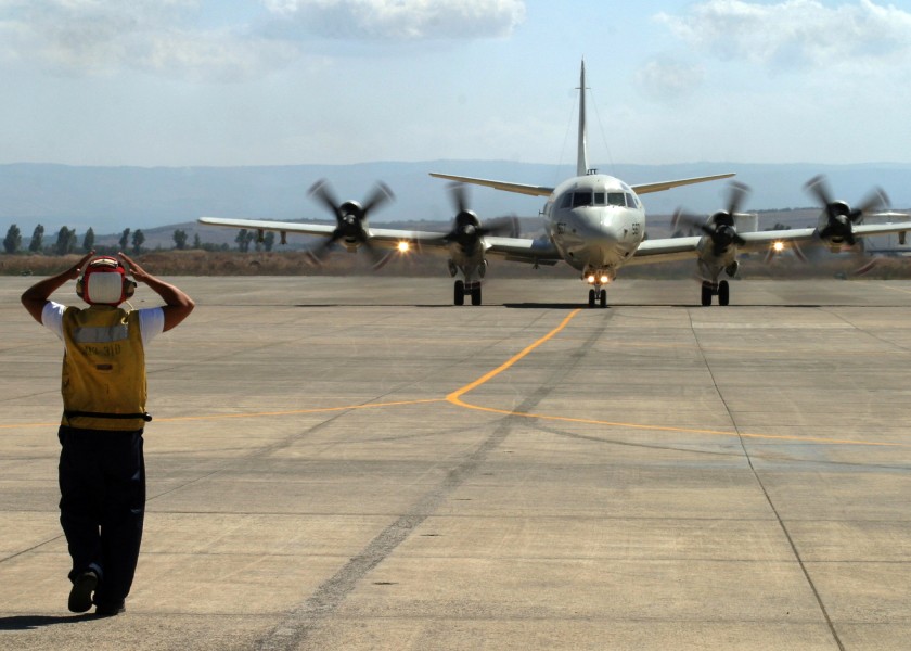 US Navy 060823-N-3013W-003 Aviation Ordnanceman 3rd Class Giancarlo Rosasarias of Los Angeles, Calif., directs the taxi pilot to straighten his direction of movement in order to properly park a P-3C Orion, after returning from 