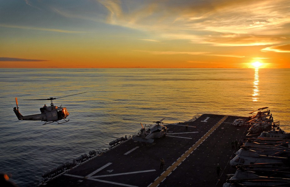 US Navy 071108-N-4774B-046 A UH-1N Huey takes off from the flight deck of amphibious assault ship USS Tarawa (LHA 1) during sunset over the Pacific Ocean