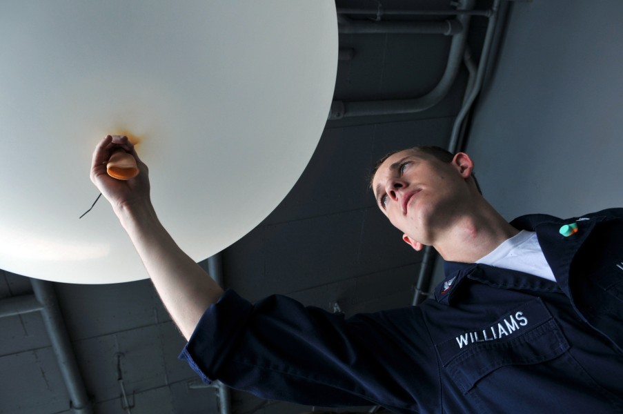 US Navy 080625-N-7981E-062 Aerographer's Mate 3rd Class Jason Williams holds a weather balloon to be fitted with a sensor package