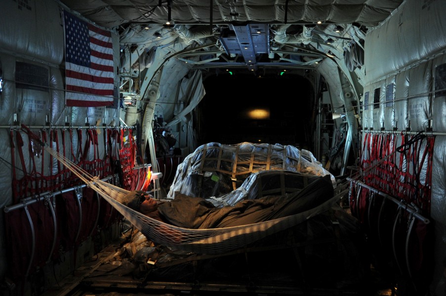 US Navy 091122-N-4154B-010 Explosive Ordnance Disposal Technician 2nd Class Edwin Sharpe rests in a hammock in the cabin of a U.S. Air Force C-130 airplane