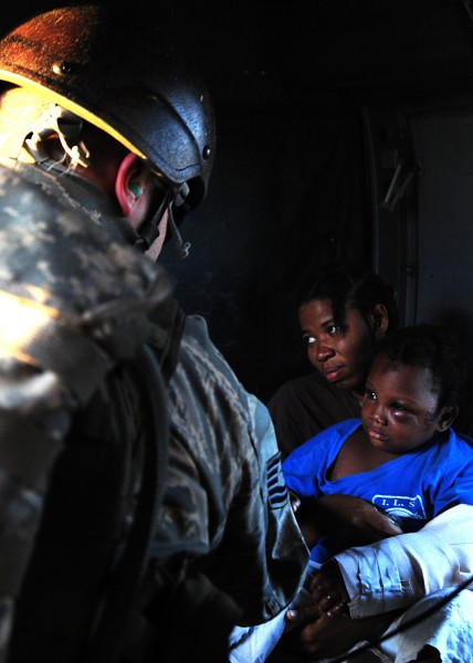 US Navy 100116-N-6247V-269 An air crewman comforts Haitian earthquake victims during a medical evacuation aboard an U.S. Navy SH-60F Sea Hawk assigned to the Red Lions of Anti-submarine Squadron (HS) 15