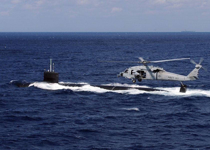US Navy 100303-N-3885H-317 An MH-60S Sea Hawk helicopter from Helicopter Sea Combat Squadron (HSC) 9 flies alongside the Virginia-class attack submarine USS New Mexico (SSN 779)