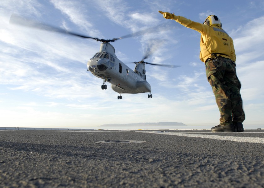 US Navy 101105-N-2515C-126 Aviation Boatswain Mate (Handling) 3rd Class Troy Palomino signals a CH-46E Sea Knight helicopter to take off