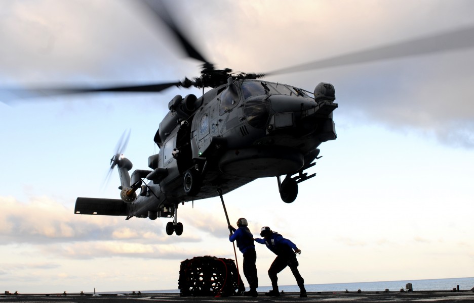 US Navy 110910-N-BC134-468 Seaman Jun Jiang, left, and Gabriel Wafula connect a cargo pendant to an MH-60 Sea Hawk helicopter