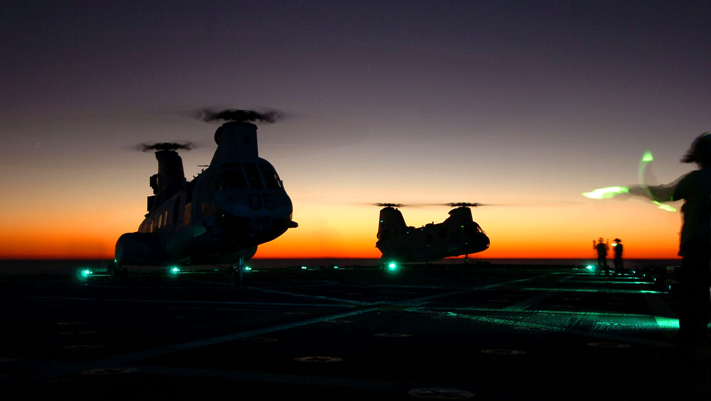US Navy 061029-N-4236E-001 Two CH-46 Sea Knights land on the flight deck during night operations aboard the amphibious transport dock USS Shreveport (LPD 12)