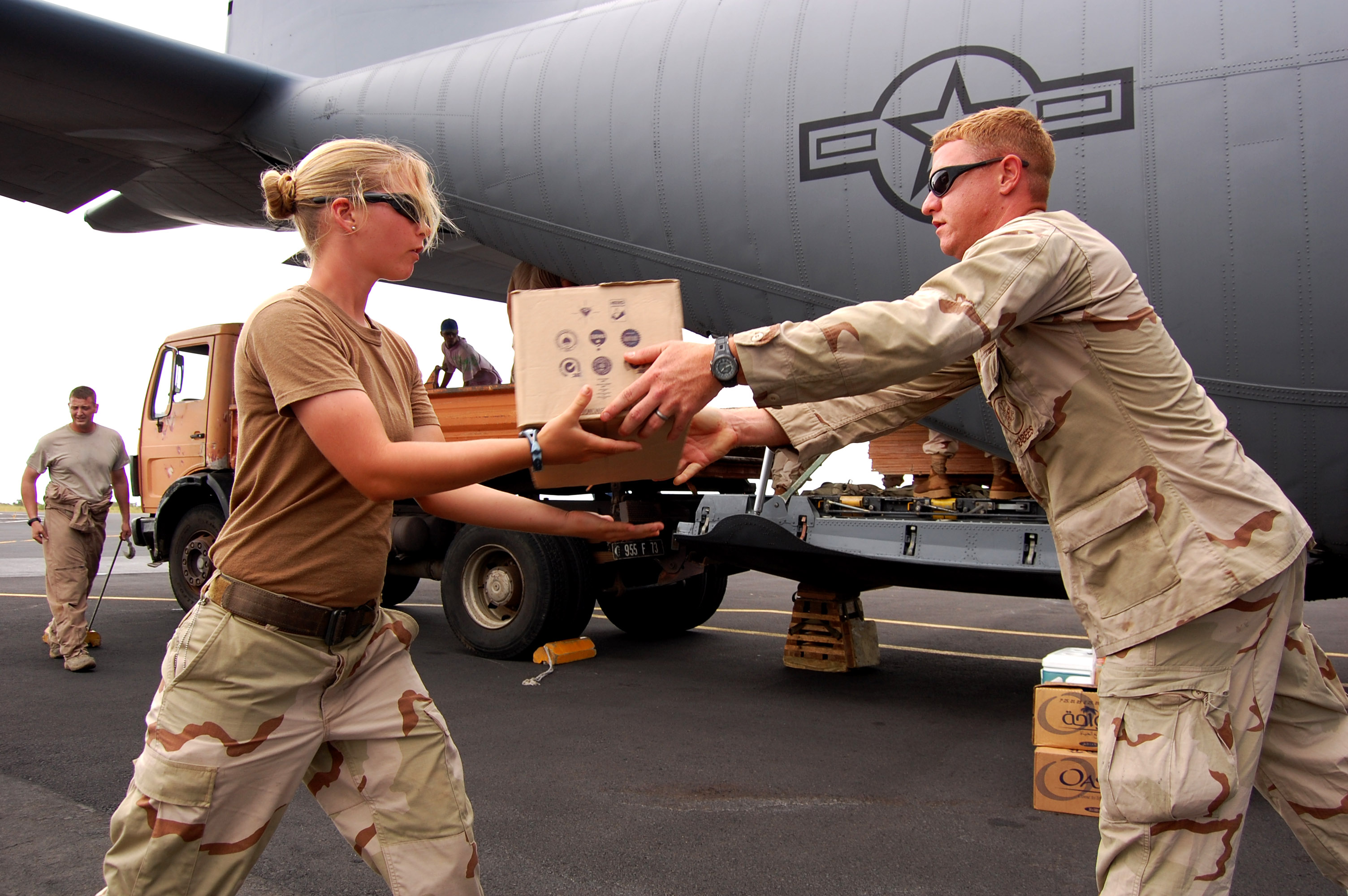 US Navy 090424-N-1057H-498 Seabees assigned to Naval Mobile Construction Battalion (NMCB) 11, Detachment Horn of Africa offload supplies from an Air Force C-130 Hercules cargo plane