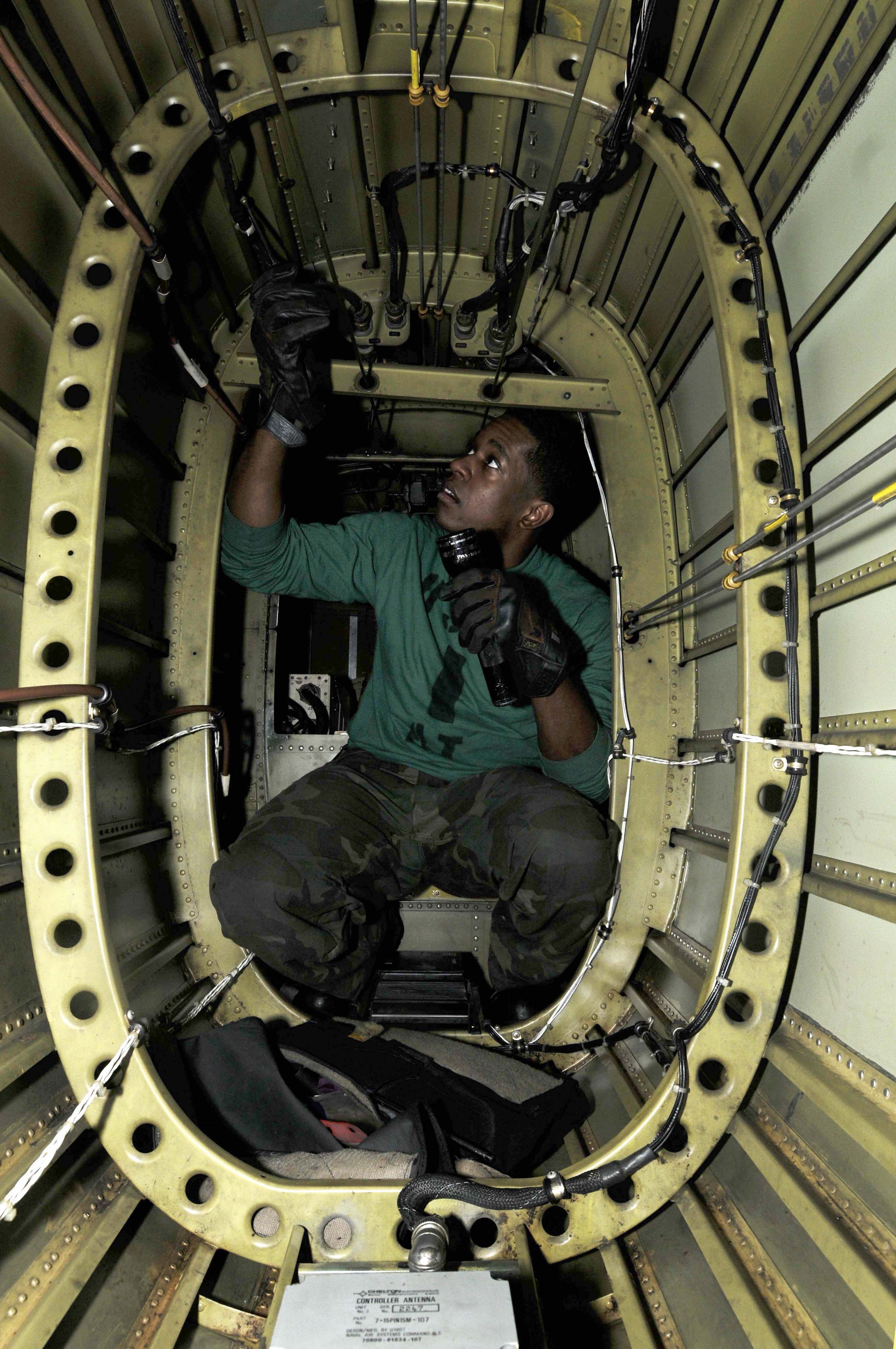US Navy 091216-N-3038W-084 Aviation Electronics Technician 3rd Class Robert Cager performs maintenance on the electrical system in the tail section of an SH-60F Sea Hawk helicopter