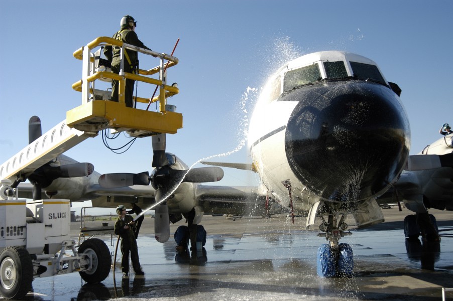 US Navy 030313-N-9693M-001 Aviation Maintenance Administrationman 2nd Class Richard Stepp uses a hose to rinse off the cockpit area of a P-3 Orion