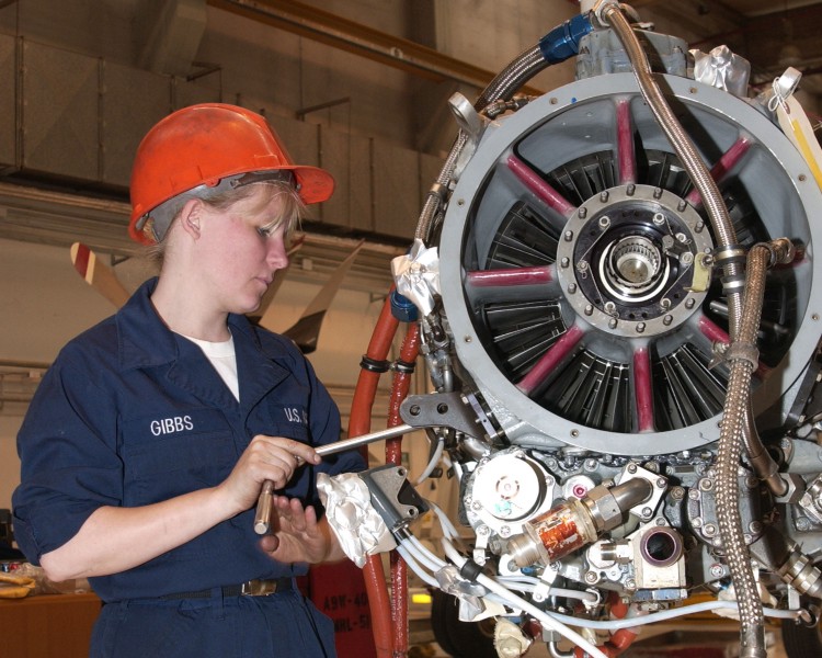 US Navy 030501-N-6484C-002 Aviation Machinist Mate Airman Melissa Gibbs works on a new power section of a engine from a C-2 Greyhound aircraft