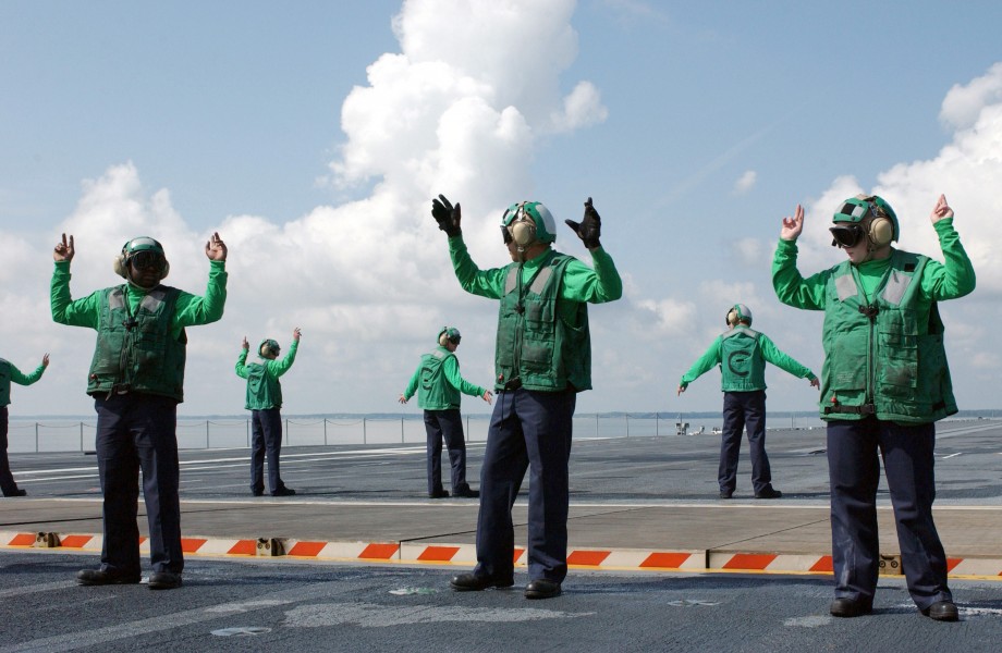 US Navy 040427-N-8148A-039 Crew members assigned to V-2 division aboard USS Ronald Reagan (CVN 76) signal to raise and lower Jet Blast Deflectors