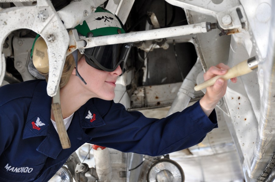 US Navy 100713-N-0941L-055 Mass Communication Specialist 2nd Class Gulianna Mandigo, assigned to the War Eagles of Patrol Squadron (VP) 16, cleans the landing gear of a P-3C Orion