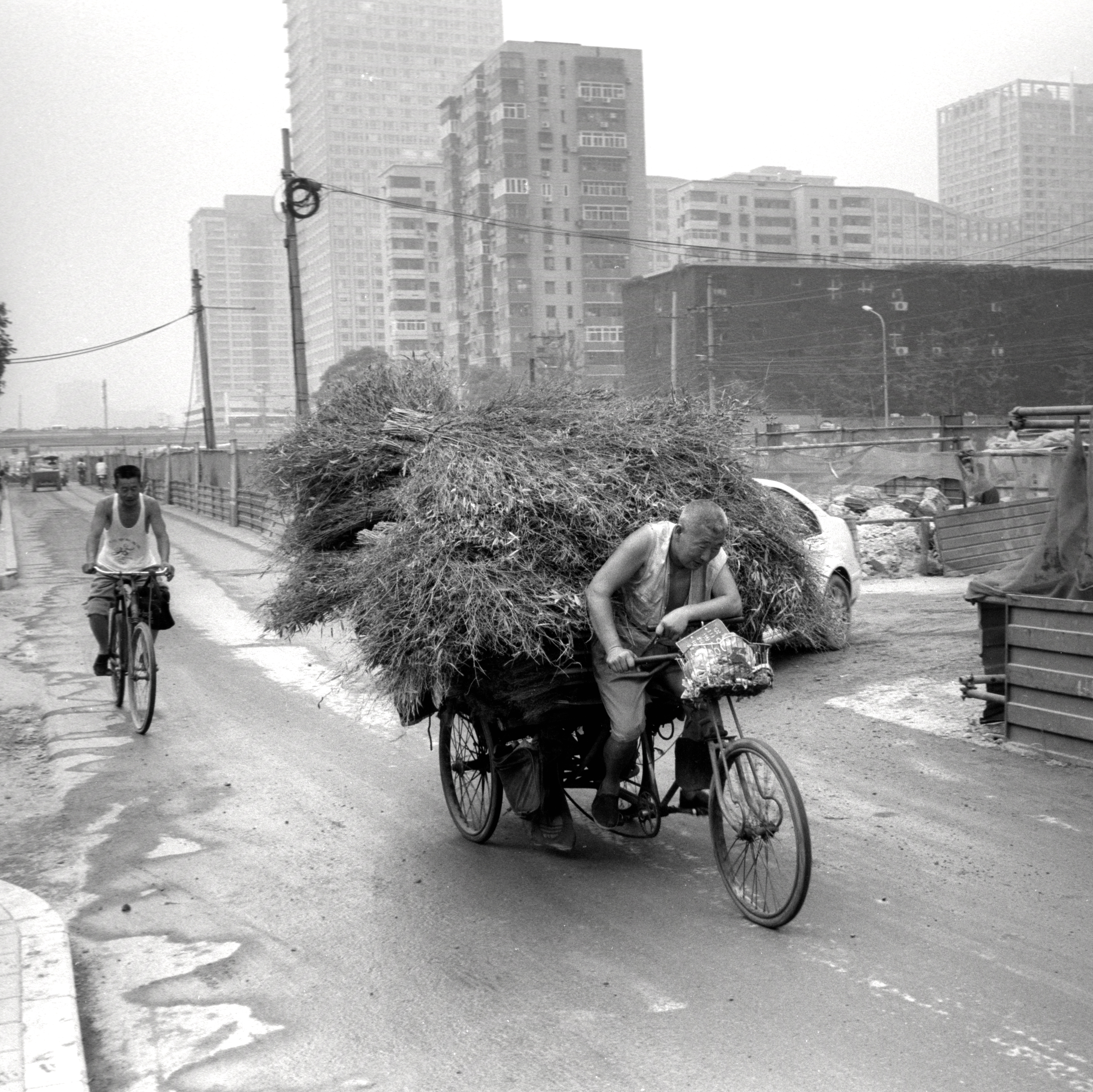 A man is riding a very loaded tricycle