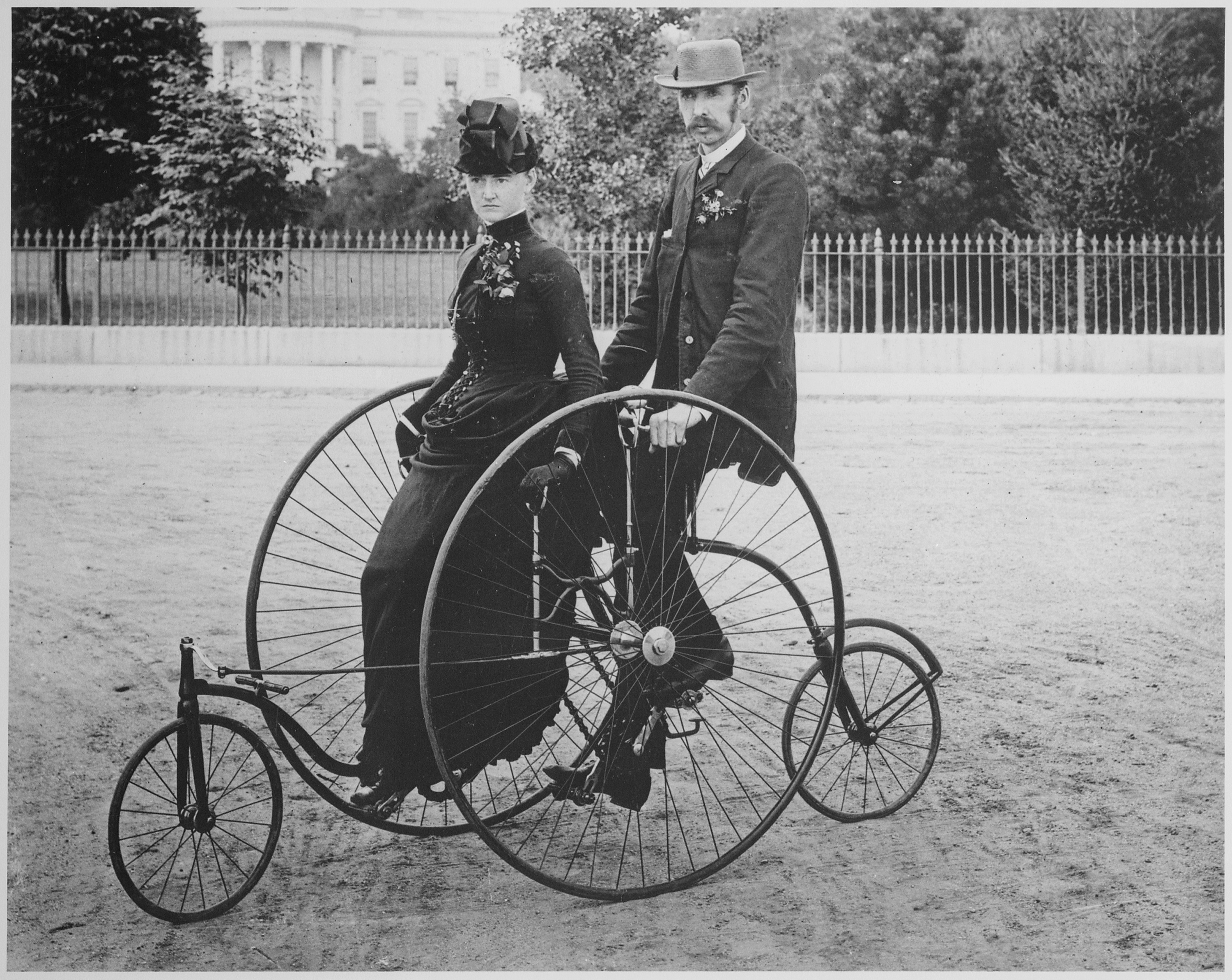 Smartly dressed couple seated on an 1886-model bicycle for two - NARA - 519711