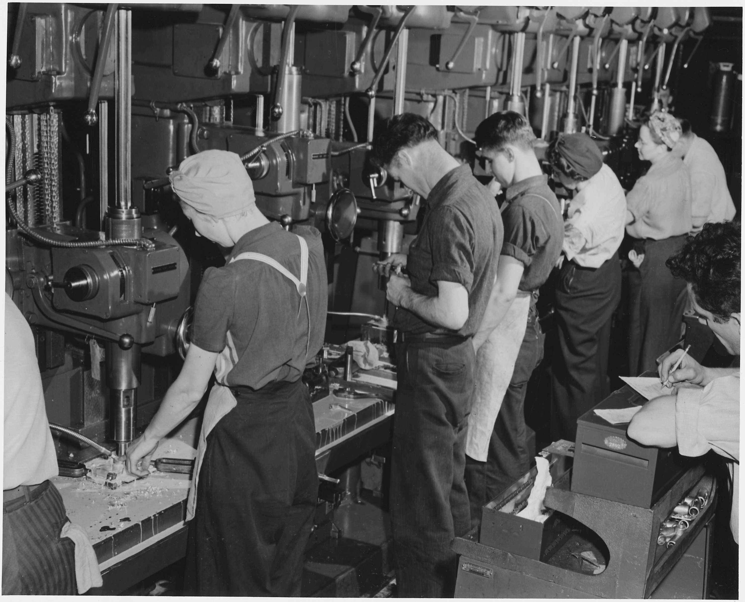 Both men and women man the machines which are turning out parts for America's bomber planes at Willow Run, Mich. - NARA - 195476