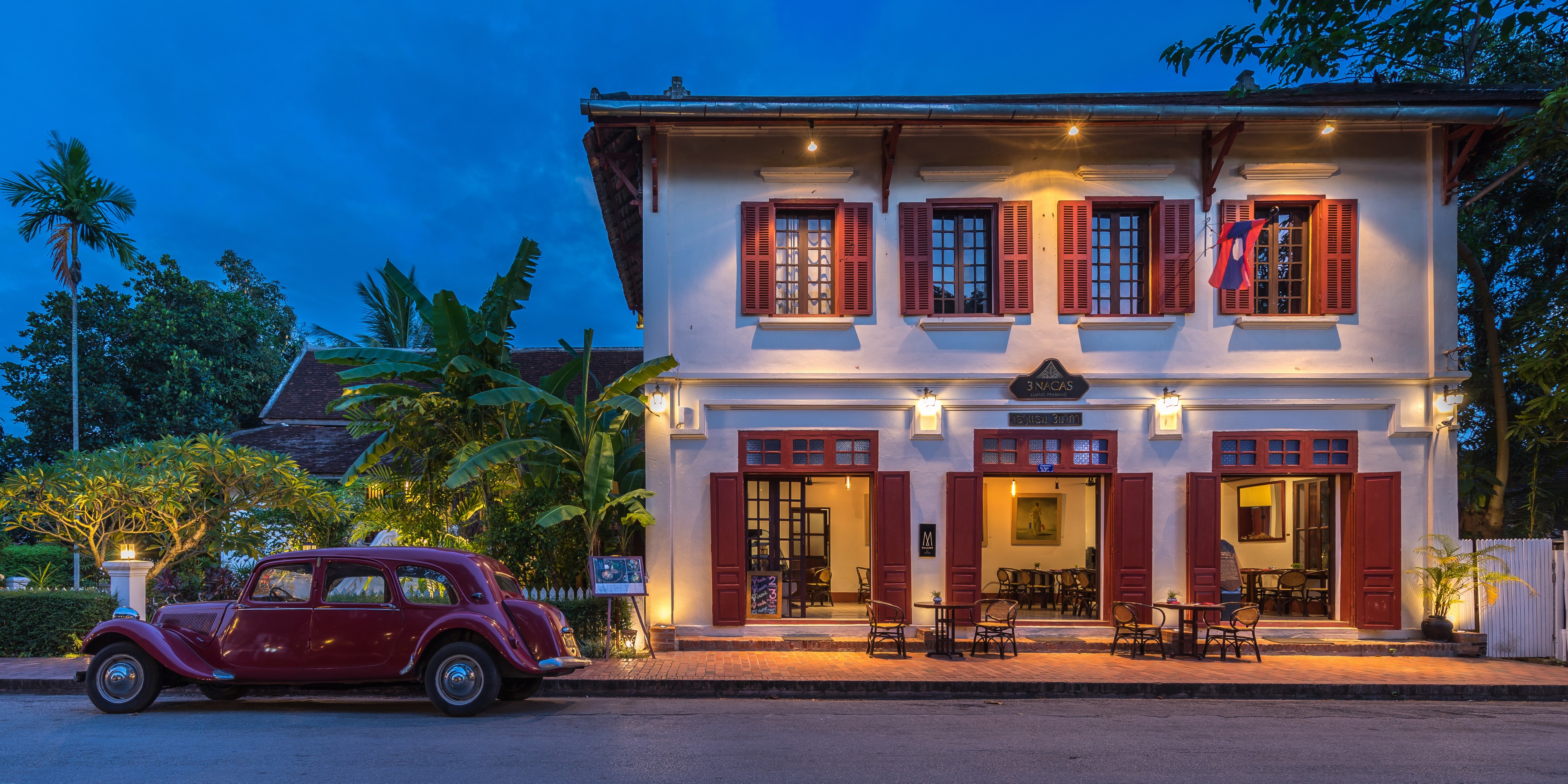 Hotel 3 Nagas with old red Citroen at blue hour in Luang Prabang