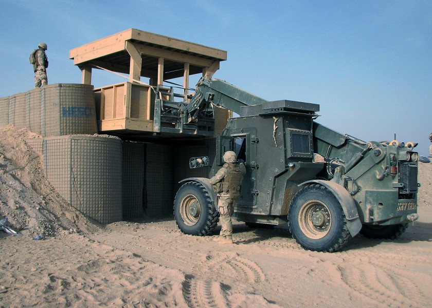 US Navy 090320-N-8547M-047 Seabees assigned to Naval Mobile Construction Battalion (NMCB) 5 uses a forklift to place a guard tower between barriers during a project