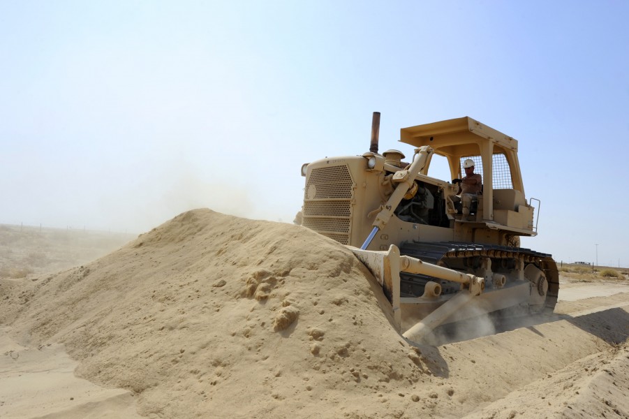 US Navy 110705-N-WL435-178 Master Chief Equipment Operator Charles Boris pushes sand with a bulldozer to reinforce an existing berm at a joint forc