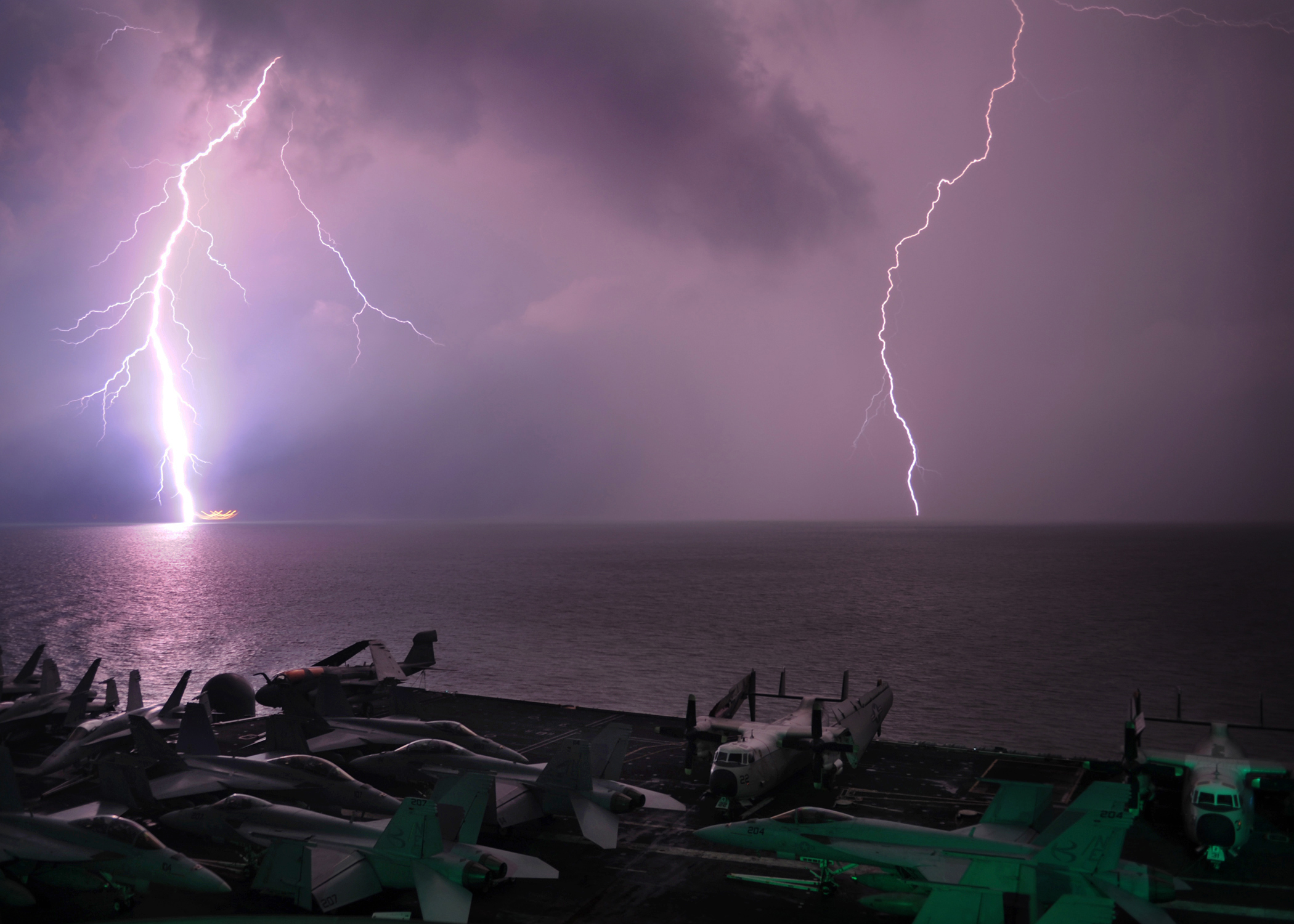 Lightning flashes as the aircraft carrier USS Abraham Lincoln (CVN 72) transits the Strait of Malacca
