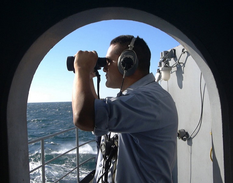 US Navy 021115-N-0879R-002 A sailor stands the aft port lookout watch while aircraft are launched and recovered from the ship^rsquo,s flight deck above