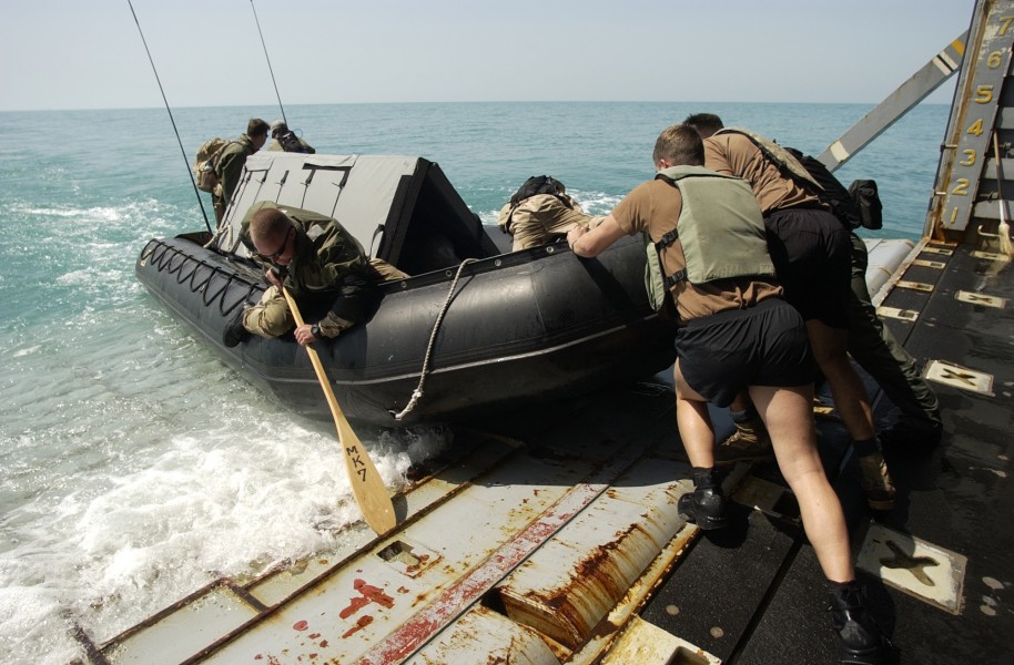 US Navy 030317-N-5319A-011 Members of the Deep-Shallow Water Mark 7 crew from Commander Task Unit (CTU-55.4.3) push their dive boat off the well deck of the USS Gunston Hall (LSD 44)