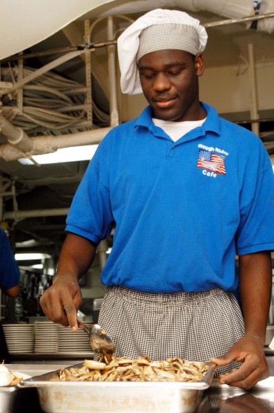 US Navy 030414-N-2410G-502 Mess Specialist Seaman Calvin Powell from Greenville, Ala. prepares a meal