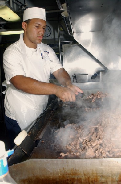 US Navy 030710-N-7732W-044 Mess Management Specialist Seamen Jean Regalado from New York, N.Y., prepares a meal in one of the six galleys aboard USS John C. Stennis (CVN 74)