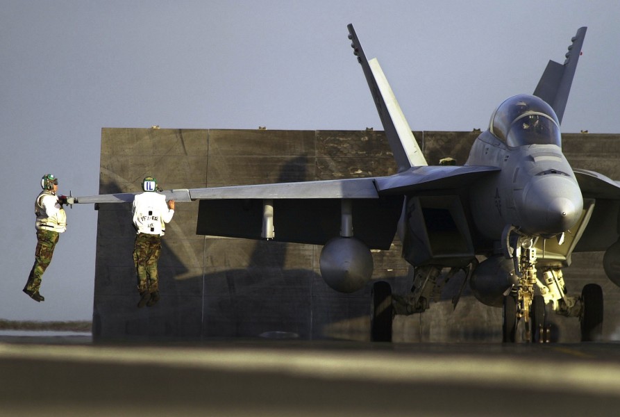 US Navy 030807-N-6213R-456 Final checkers leap in the air to inspect the aileron of an F-A-18F Super Hornet prior to launching from the flight deck of USS John C. Stennis (CVN 74)