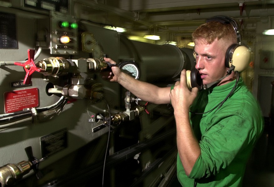US Navy 030813-N-6213R-017 Aviation Boatswain's Mate Airman Danny Donahoe adjusts the tension of arresting gear machinery under the flight deck aboard USS John C. Stennis (CVN 74)
